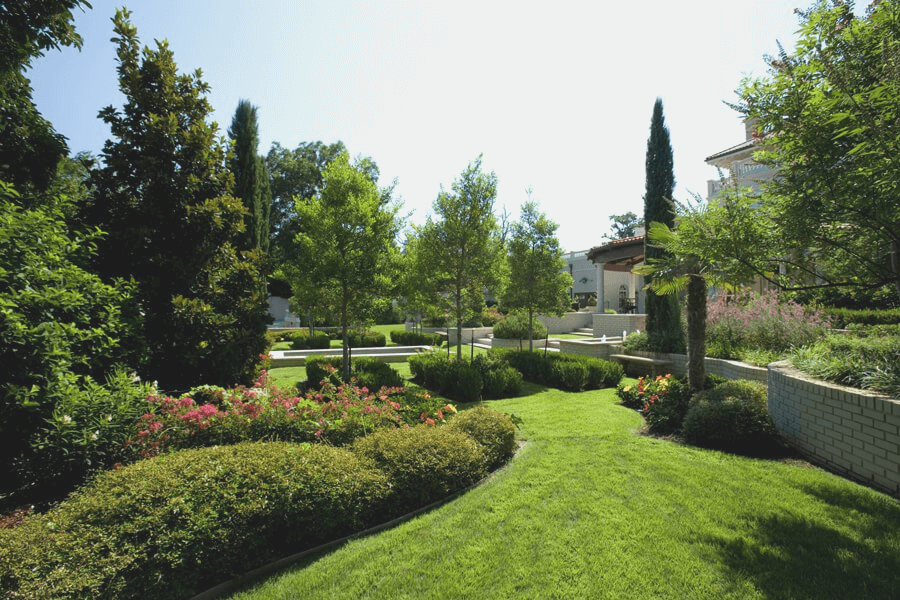 landscaped back yard with flowers, shrubs, and trees that was designed and installed by Lawn Connections